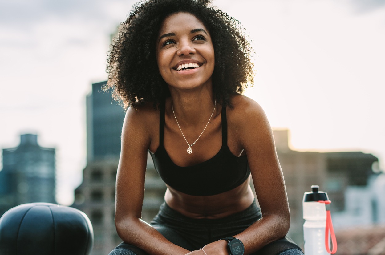Smiling woman athlete taking a break during workout