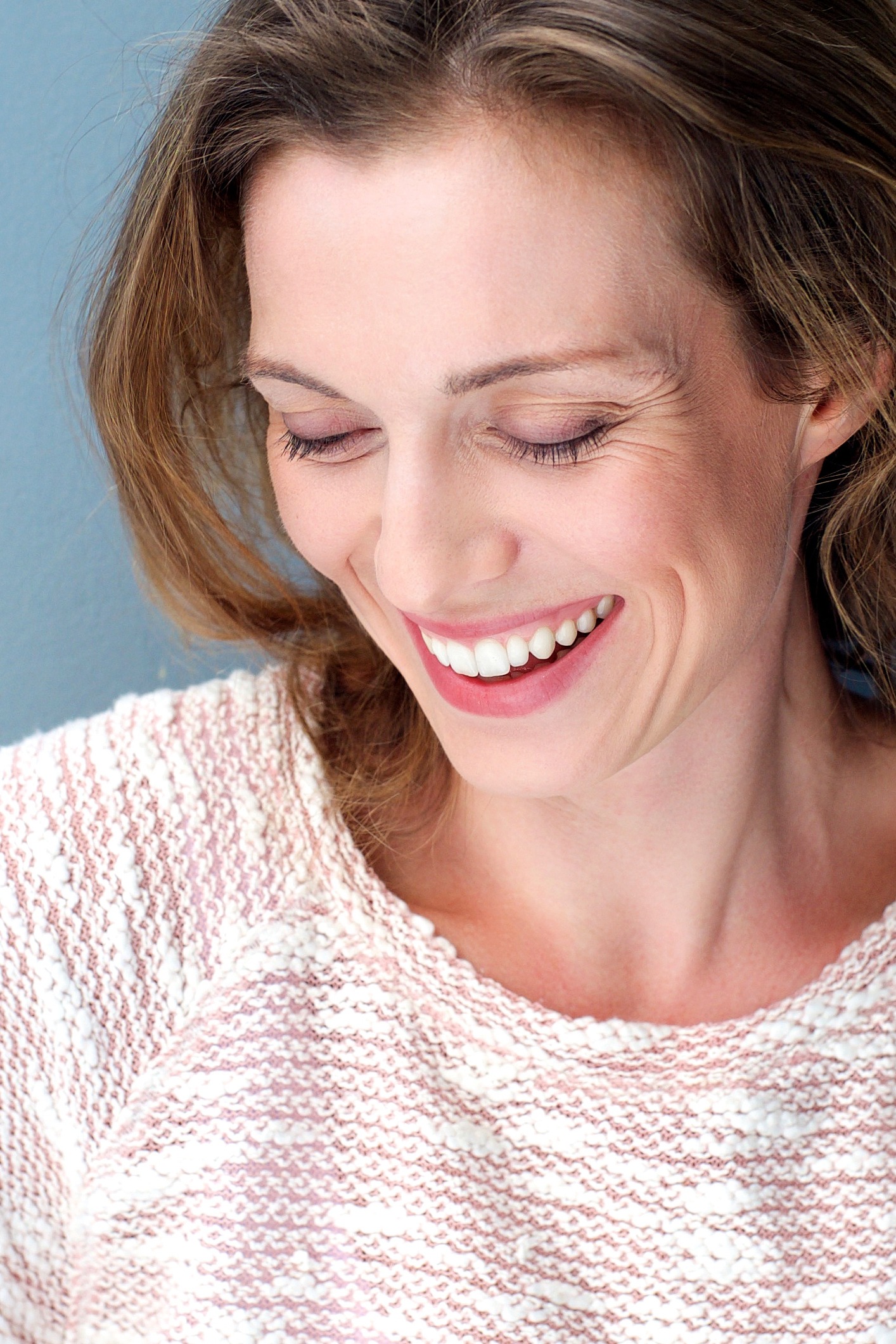 Beautiful mid adult woman laughing with sweater
