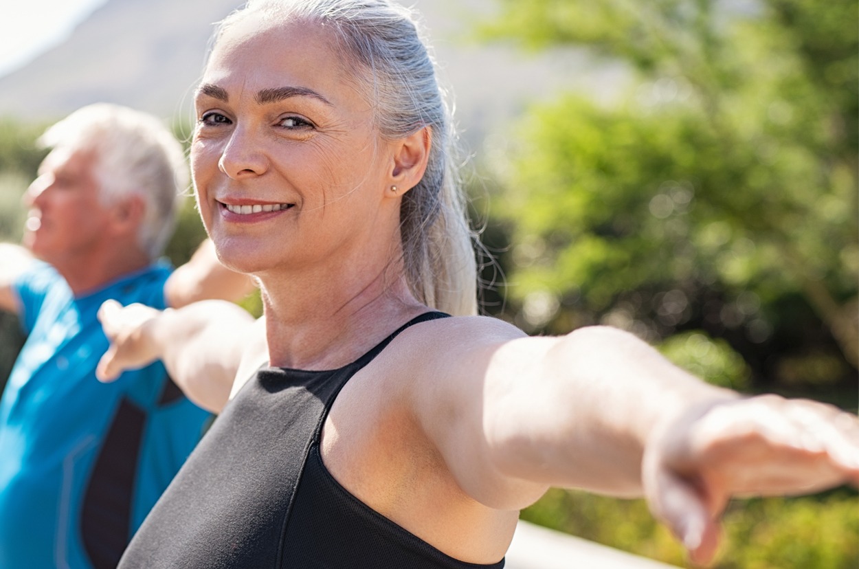 Senior woman stretching arms in yoga class