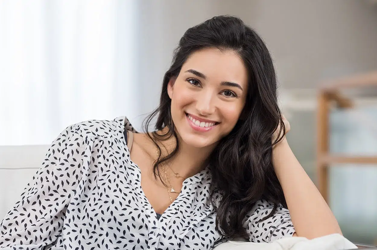 Smiling woman in a patterned shirt.